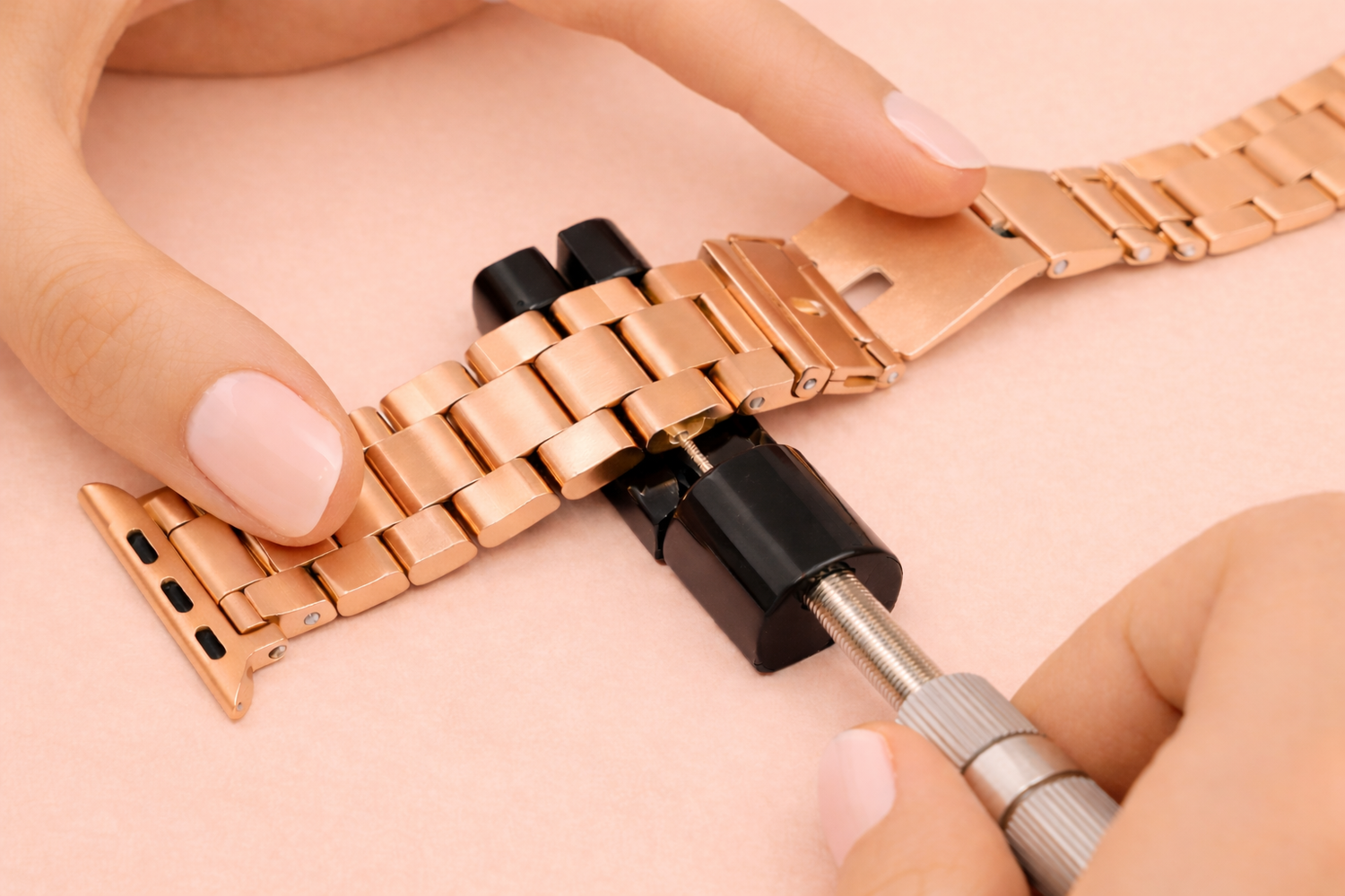 Glieder einer Metall-Armbanduhr werden mit Werkzeug eingesetzt.