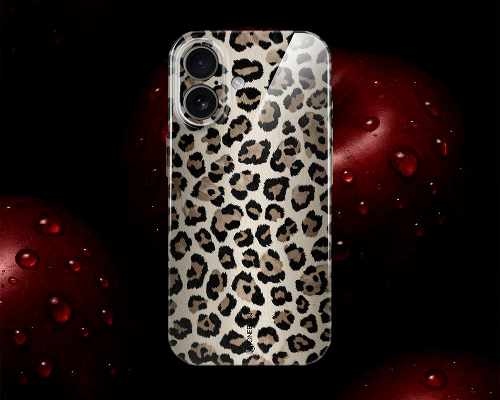 Smartphone-Hülle mit Leopardenmuster vor rotem Apfel mit Wassertropfen.